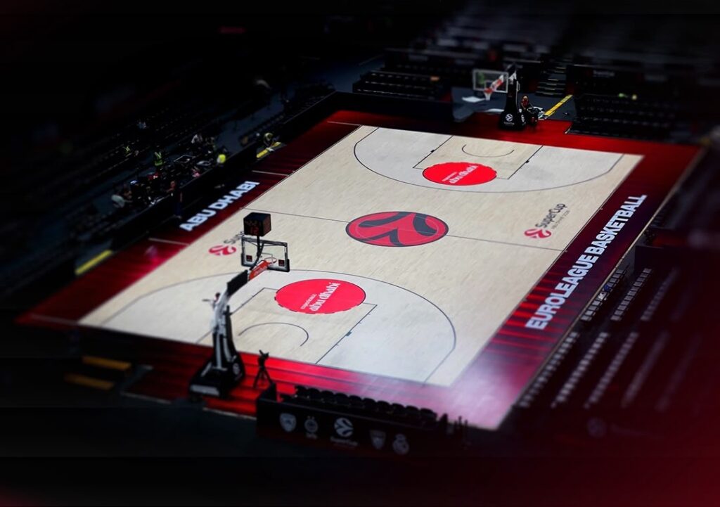 High-angle view of an illuminated EuroLeague basketball court in Abu Dhabi.